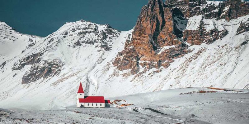 Islande-église-entourée-de-montagnes-enneigées