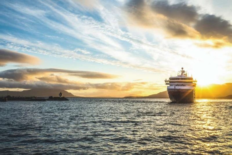 Hurtigrutenschip bij ondergaande zon