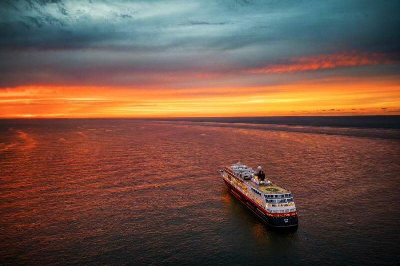 Hurtigruten schip op zee onder de middernachtzon
