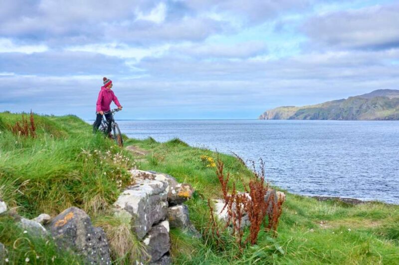 Woman-on-mountain-bike-cycling-cliffs-Dunmore head-Ireland