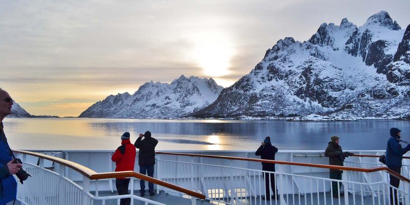 Passagiers op het dek van een Hurtigruten schip tijdens een zeereis met Nordic in de winter